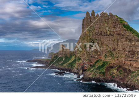 Close-up shot of famous Drangarnir cliff with Tindholmur islands in the background taken during early morning hike in spring at Faroese coastline Faroe Island, Denmark, Europe. High quality photo 132728599