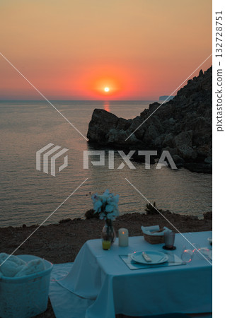 A cozy and picturesque location in Malta, perfect for a romantic date, overlooking the sea as the sun sets, casting warm golden hues over the Mediterranean horizon. 132728751
