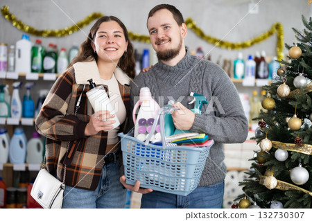 Happy couple shopping for cleaning products and toiletries in festive store 132730307