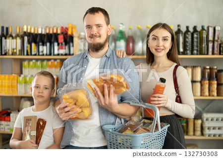 Couple of man and woman with boy choosing food in grocery 132730308