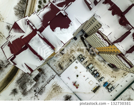 Aerial winter top view of modern big apartment building in suburb area at narrow dirty road and snowy field. Aerial winter top view of modern big apartment building in suburb area at narrow dirty road and snowy field. 132730381
