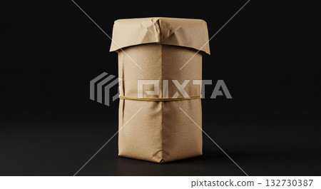 Brown Paper Wrapped Gift with Tan Rubber Band on Dark Background Brown Paper Wrapped Gift with Tan Rubber Band on Dark Background 132730387