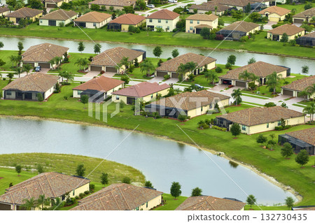 Aerial view of tightly located family houses with retention ponds to prevent flooding in Florida closed suburban area. Real estate development in american suburbs Aerial view of tightly located family houses with retention ponds to prevent flooding in Florida closed suburban area. Real estate development in american suburbs 132730435