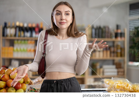 Female shopper has difficulty remembering what to buy at grocery supermarket Female shopper has difficulty remembering what to buy at grocery supermarket 132730438