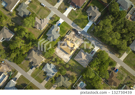 Aerial view of suburban private house wit wooden roof frame under construction in Florida quiet rural area 132730439