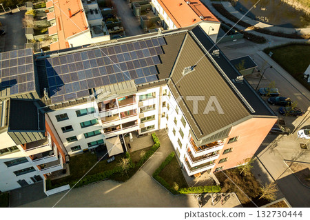 Aerial view of solar photovoltaic panels on a roof top of residential building block for producing clean electric energy. Autonomous housing concept. 132730444