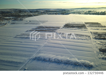 Aerial view of snow covered agricultural fields with barren surface in winter Aerial view of snow covered agricultural fields with barren surface in winter 132730446