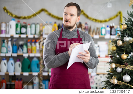 Man employee with paper, plans to replenish restock stores inventory on Christmas Eve 132730447