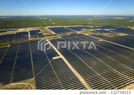 Aerial view of large sustainable electrical power plant with rows of solar photovoltaic panels for producing clean electric energy. Concept of renewable electricity with zero emission Aerial view of large sustainable electrical power plant with rows of solar photovoltaic panels for producing clean electric energy. Concept of renewable electricity with zero emission 132730513