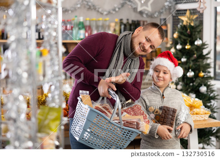 Dad and son are choosing products for New Year celebration in supermarket 132730516