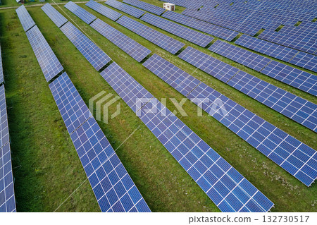 Aerial view of large sustainable electrical power plant with rows of solar photovoltaic panels for producing clean electric energy. Concept of renewable electricity with zero emission Aerial view of large sustainable electrical power plant with rows of solar photovoltaic panels for producing clean electric energy. Concept of renewable electricity with zero emission 132730517