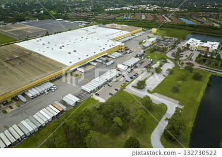 Aerial view of large commercial distribution center with many trucks unloading and uploading retail products for further shipment. Global economy concept 132730522