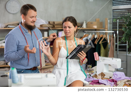 Frustrated female designer waving off bothersome colleague flirting 132730530