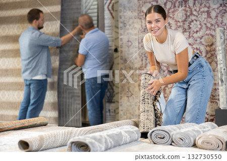 Young woman choosing carpet in building store Young woman choosing carpet in building store 132730550