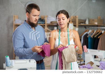 Female fashion designer discussing fabric options with client 132730662