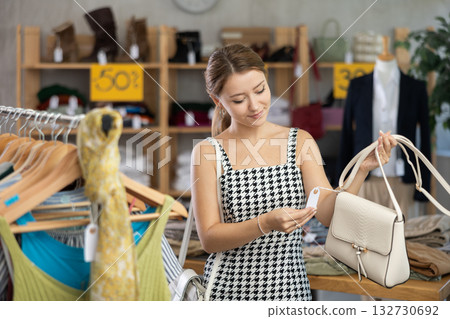 Young woman choosing a bag in a store on sale Young woman choosing a bag in a store on sale 132730692