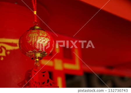 Red lantern with golden decorations suspended in a festive space Red lantern with golden decorations suspended in a festive space 132730743