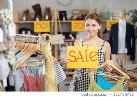 Young woman holding poster with the inscription sale Young woman holding poster with the inscription sale 132730756