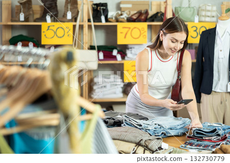 Female shopper scanning shorts tag in discount store Female shopper scanning shorts tag in discount store 132730779