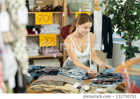 European woman choosing pants in a clothing store European woman choosing pants in a clothing store 132730781