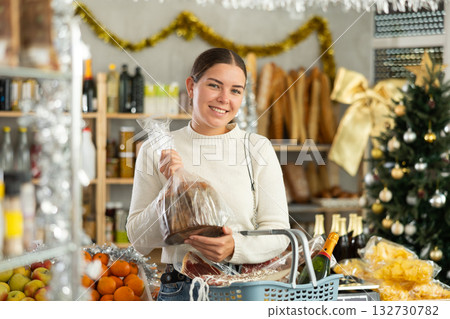 Young woman choosing panettone for Christmas celebrations in grocery store 132730782