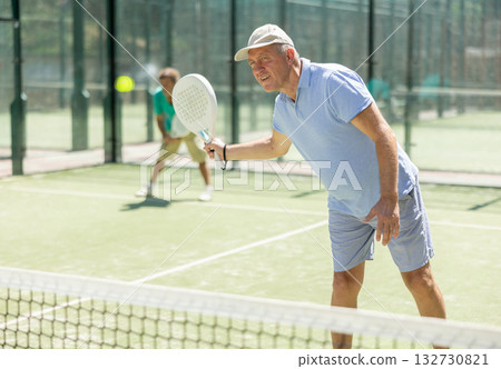 Elderly and adult men playing doubles padel Elderly and adult men playing doubles padel 132730821
