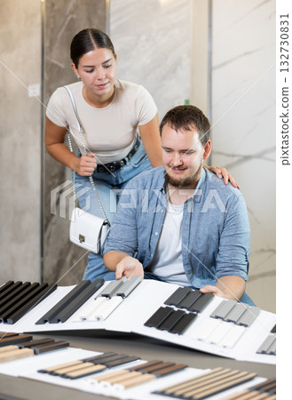 Married copule chooses decorative wall or floor coverings for home with interest Married copule chooses decorative wall or floor coverings for home with interest 132730831