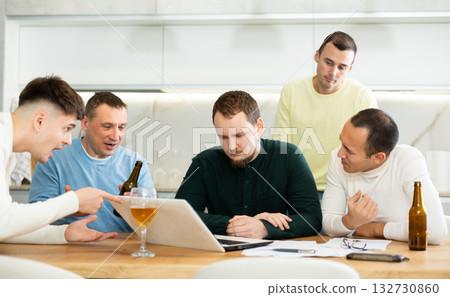 Worried male friends trying to solve problem together on laptop 132730860