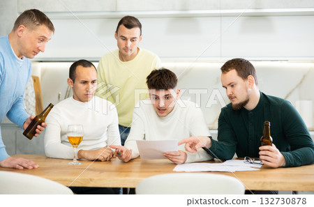 Friends consoling upset worried man reading unexpected medical results Friends consoling upset worried man reading unexpected medical results 132730878