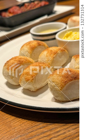 Few pieces of small bread with butter and sauce on white dish 132731314