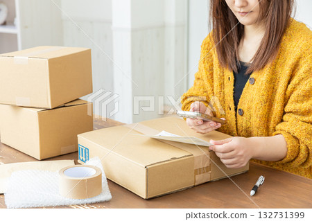 A woman preparing to ship a package A woman preparing to ship a package 132731399