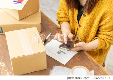 A woman preparing to ship a package A woman preparing to ship a package 132731405