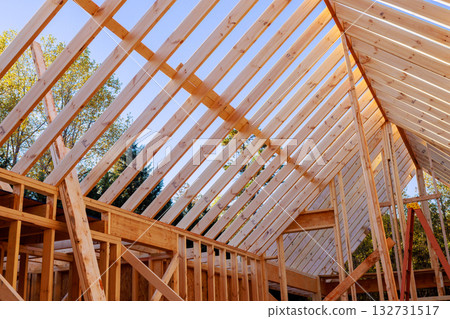 Construction workers make progress on house with wooden beams rafters Construction workers make progress on house with wooden beams rafters 132731517