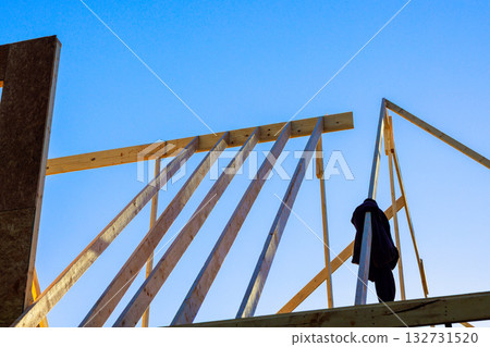 Wood beams are being installed on building structure worker jacket hanging nearby. Wood beams are being installed on building structure worker jacket hanging nearby. 132731520