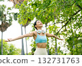 Young Asian woman relaxed breathing fresh air with trees in the background  132731763