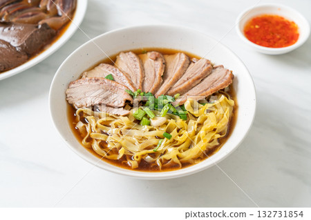 egg noodles with stewed duck in brown soup 132731854