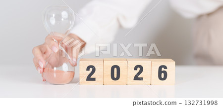 Happy New Year 2026 with hourglass on table. Resolution, time, plan, goal, motivation, reboot, countdown and New Year holiday concepts 132731998