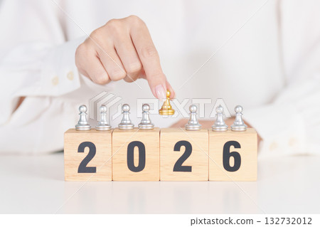 hand holding man chess figure from the crowd employee with 2026 Year block. Human resource management, Recruitment, Teamwork, strategy, toxic people and leadership Concepts 132732012