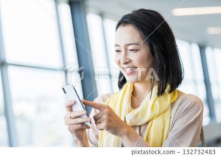 一位女性商務人士正在使用智慧型手機。 一位女性商務人士正在使用智慧型手機。 132732483