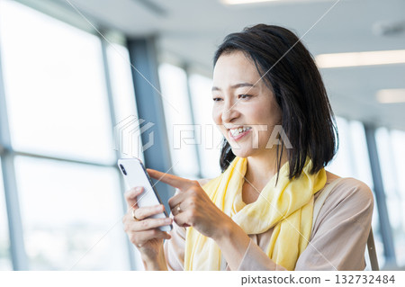 A female business person operating a smartphone. 132732484