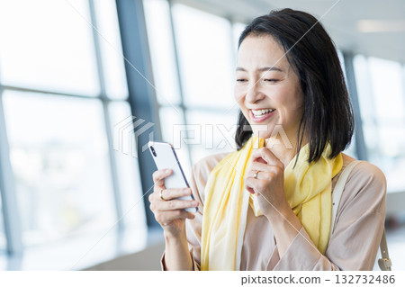 一位女性商務人士正在使用智慧型手機。 132732486