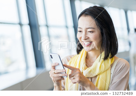 一位女性商務人士正在使用智慧型手機。 132732489