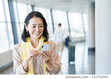 A female business person operating a smartphone. A female business person operating a smartphone. 132732493