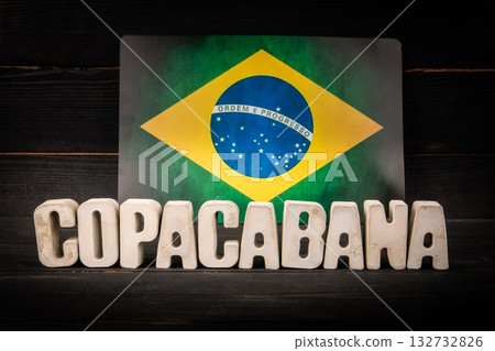 Brazilian flag with bold Copacabana text in front, representing Rio de Janeiro. Tourism, culture and Brazilian flag with bold Copacabana text in front, representing Rio de Janeiro. Tourism, culture and 132732826