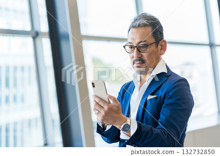 A middle-aged man operating a smartphone. 132732850