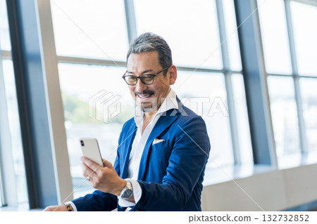 一位中年男子正在操作智慧型手機。 132732852