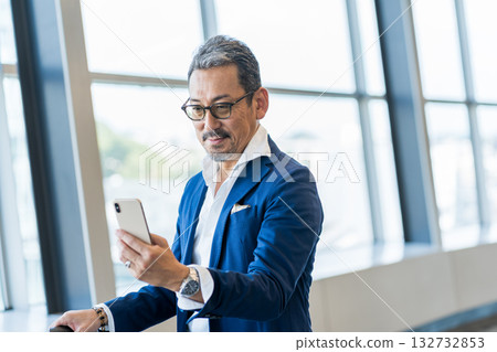 一位中年男子正在操作智慧型手機。 132732853
