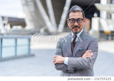 一位雙臂交叉的中老年商人 一位雙臂交叉的中老年商人 132733125