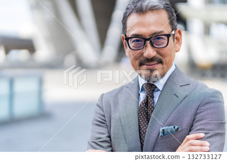 一位雙臂交叉的中老年商人 132733127