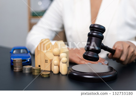 Judge hitting gavel with house family car and coins on table, legal decision and property concept 132733180